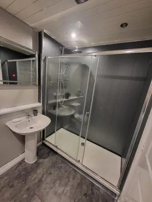 a bathroom with a glass shower and a sink at Harbour Point -Coorie Doon Stays in Saltcoats