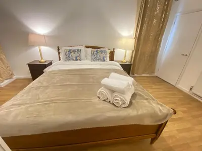 a bedroom with a large bed with two towels on it at Luxurious 3 rooms greater London in Moffat