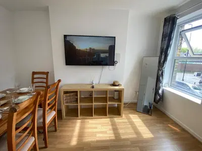 a dining room with a table and a television on a wall at Luxurious 3 rooms greater London in Moffat