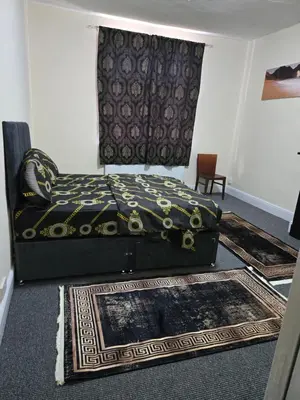 a bed sitting in a room with a rug at Carlton road in Moffat