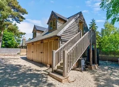 a wooden house with a staircase leading up to it at Edinburgh's Springtime Chalet in Roslin