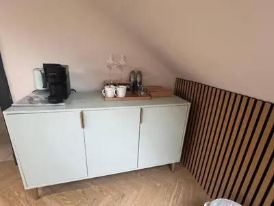 a white cabinet with wine glasses on top of it at Fergus in ApartNest Auchterarder in Auchterarder
