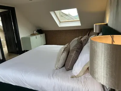 a bedroom with a white bed with pillows and a window at Fergus in ApartNest Auchterarder in Auchterarder