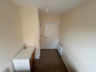 an empty room with a desk and a door at Cosy Room with Shared Bathroom in Edinburgh