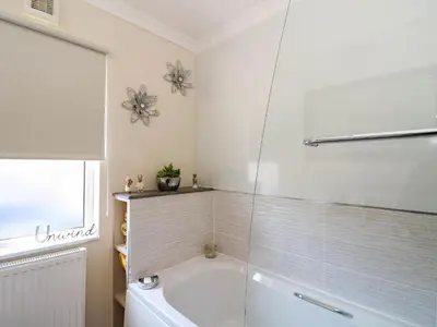 a bathroom with a tub with a glass shower at RoseGrace Lodge in Auchterarder