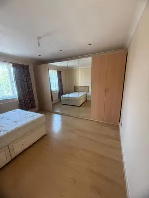 an empty bedroom with a bed and a mirror at Harrow Inn Rooms in Yarrow