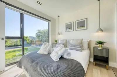 a bedroom with a bed and a large window at Retreat to the Campsies in Lennoxtown