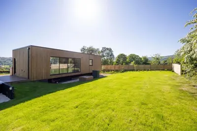 a modern house with a large grassy yard at Retreat to the Campsies in Lennoxtown