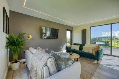 a living room with two couches and a tv at Retreat to the Campsies in Lennoxtown
