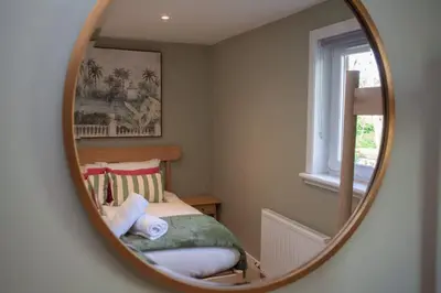 a bedroom with a bed and a mirror at Newly Renovated House in Popular Location in Glasgow