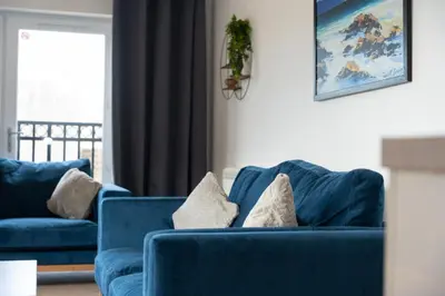 a blue couch with pillows in a living room at Macallan Apartment in Oban