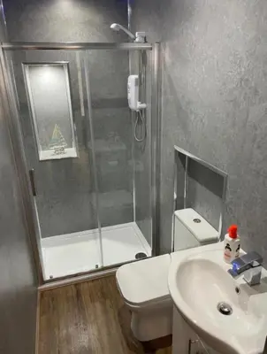 a bathroom with a shower and a toilet and a sink at Kames Bay Couples Retreat in Millport