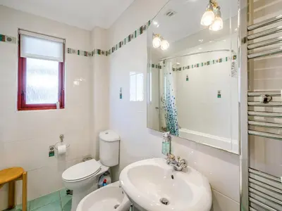 a bathroom with a sink and a toilet and a mirror at Kilbride in Lamlash