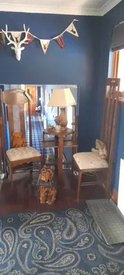 a living room with chairs and a table with a lamp at Riverside House in Callander