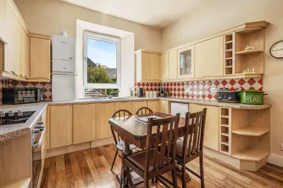 a kitchen with a table and chairs and a window at Stunning 2BR Apt - Central, Argyll Square Views in Oban