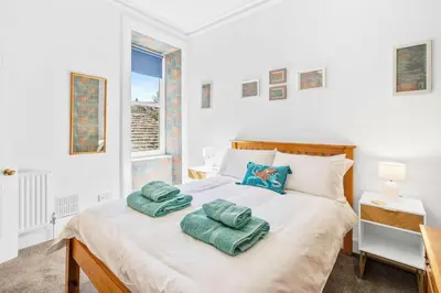 a bedroom with a bed with two towels on it at Stunning 2BR Apt - Central, Argyll Square Views in Oban