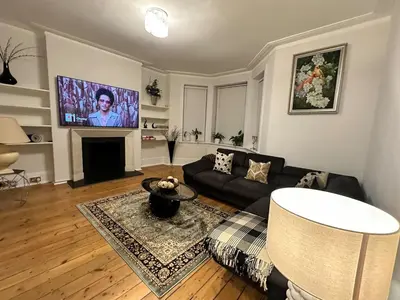a living room with a couch and a tv at Cosy Double Bedroom in Little Venice, Maide Vale in Moffat