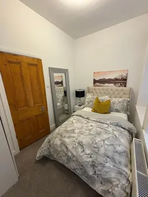 a bedroom with a large bed with a yellow pillow at Cosy Double Bedroom in Little Venice, Maide Vale in Moffat