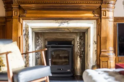 a fireplace with a wooden frame in a living room at Luxury Wood panelled West End GF Flat in Edinburgh