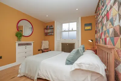 a bedroom with a white bed and a mirror at Luxury Wood panelled West End GF Flat in Edinburgh