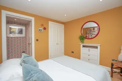 a bedroom with a white bed and a mirror at Luxury Wood panelled West End GF Flat in Edinburgh
