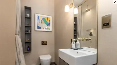 a bathroom with a sink and a toilet and a mirror at Luxury Wood panelled West End GF Flat in Edinburgh