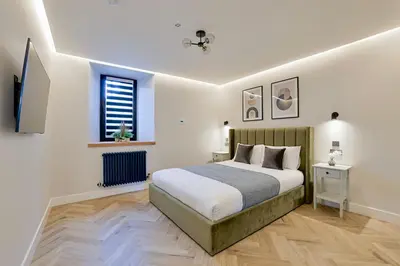 a bedroom with a bed and a television in it at Modern apartment in town centre in Oban