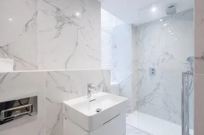 a white bathroom with a sink and a shower at 3BR Gem West End Walk to Glasgow Uni Parking in Glasgow