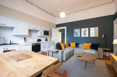 a kitchen and living room with a couch and a table at 3BR Gem West End Walk to Glasgow Uni Parking in Glasgow