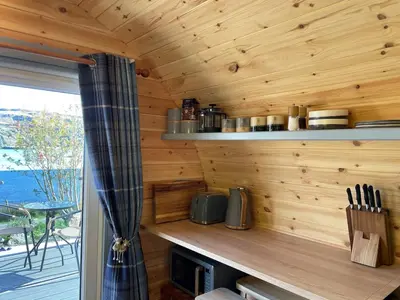 a log cabin kitchen with a counter and a window at Luxury Pod and Sauna with Fantastic Sea Views in Oban