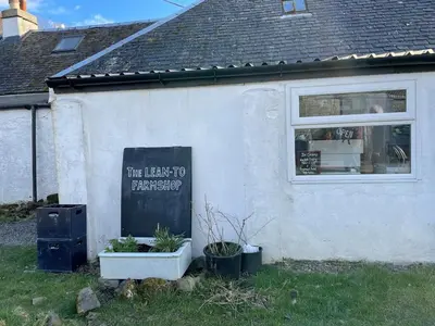 a white building with a sign on the side of it at Luxury Pod and Sauna with Fantastic Sea Views in Oban