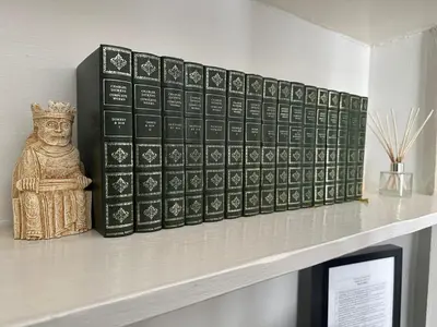 a shelf with a row of books and a statue at Grindlay St - Fantastic 2BR in Theatre District in Edinburgh