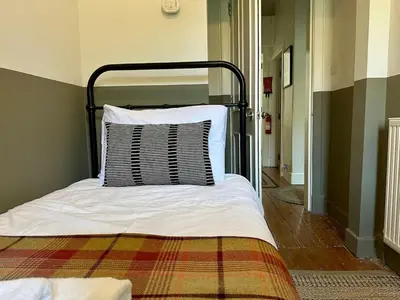 a bed with a pillow on it in a room at Grindlay St - Fantastic 2BR in Theatre District in Edinburgh