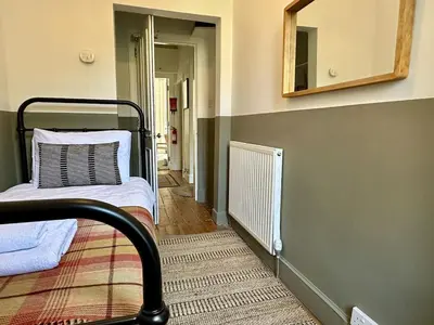 a room with a bed and a mirror and a hallway at Grindlay St - Fantastic 2BR in Theatre District in Edinburgh