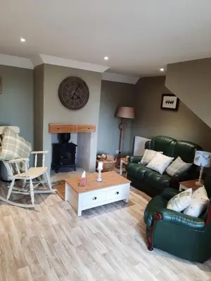 a living room with a green couch and a fireplace at A Stylish Country Retreat! in Keilour