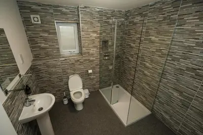 a bathroom with a toilet and a sink and a shower at Glenfiddich Apartment in Oban