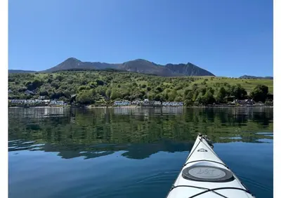 a kayak on a lake with mountains in the background at Eldon Cottage in Isle of Arran