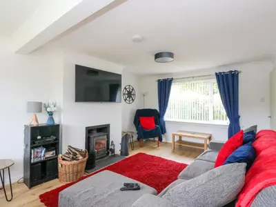 a living room with a couch and a fireplace at 3 Whin Bank in Oban