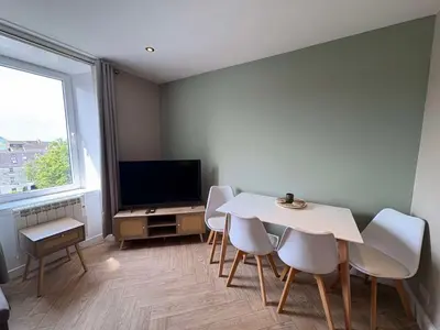 a living room with a table and chairs and a tv at Central Oban 2BR Short walk to Ferries and Harbour in Oban