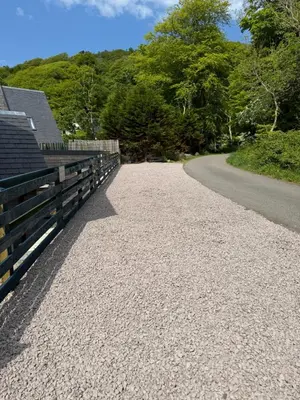 a gravel road with a fence on the side of a road at Oban House House in Oban