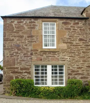 a brick building with a white window on it at Cottage in Crieff in Crieff