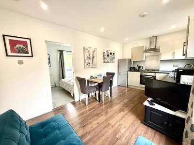 a kitchen and a living room with a table and chairs at South Gyle House - SuperFast WiFi and Free Parking - 7 minutes from Edinburgh Airport in Edinburgh