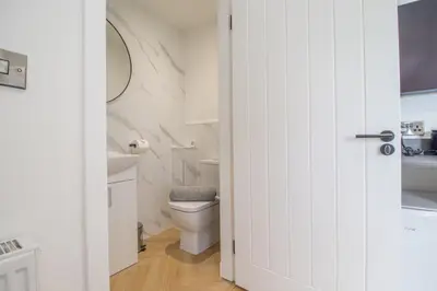 a white bathroom with a toilet and a sink at Alexandra Apartment - Single Room #1 in Falkirk