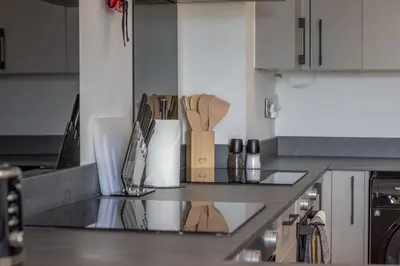 a kitchen with a counter top with wooden utensils at Alexandra Apartment - Single Room #1 in Falkirk