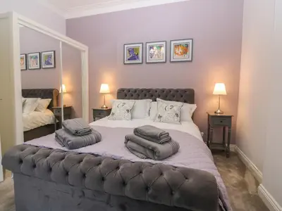 a bedroom with a large bed with two pillows on it at 60E Wellgate in Lanark