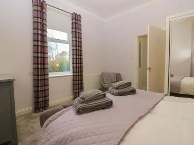 a bedroom with a bed with two towels on it at 60E Wellgate in Lanark