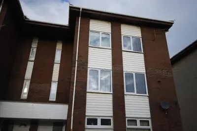a brick building with white doors and windows at Stylish Coastal Retreat in Saltcoats in Stevenston