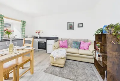 a living room with a couch and a table at Bathach Beag in Oban