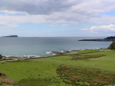 a green field with a view of the ocean at Bathach Beag in Oban