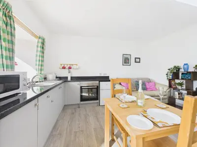 a kitchen and dining room with a wooden table at Bathach Beag in Oban